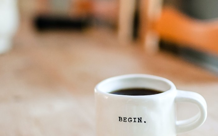 White cup with "begin" written on it. Liam Hennessy, Digital Strategist